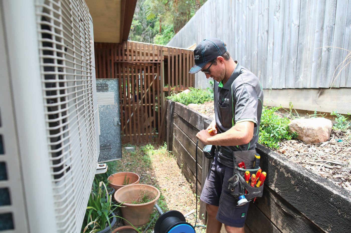 Renew technician servicing an air conditioning unit
